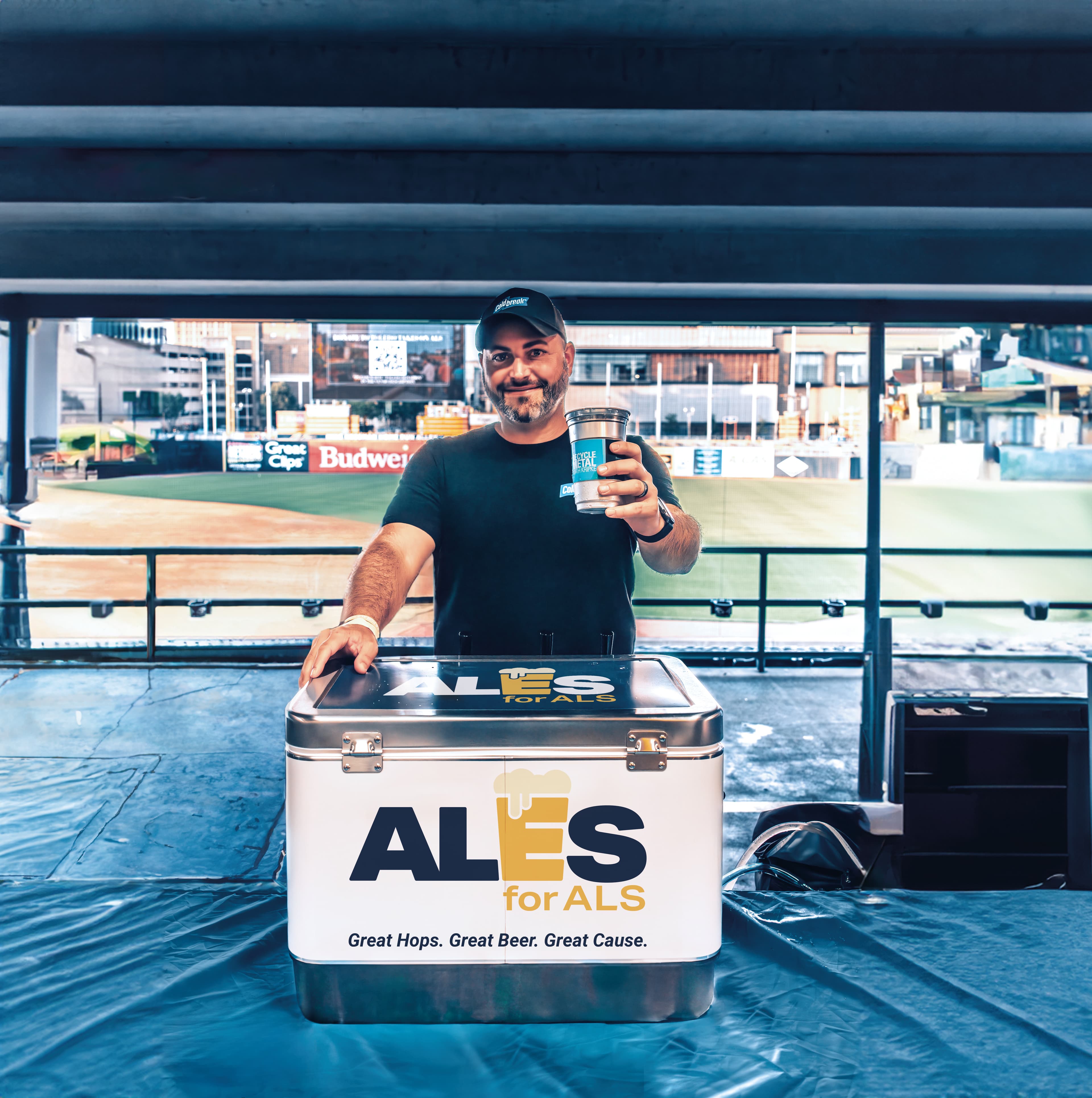 Beertender holds out cup from behind a Ales for ALS branded cooler