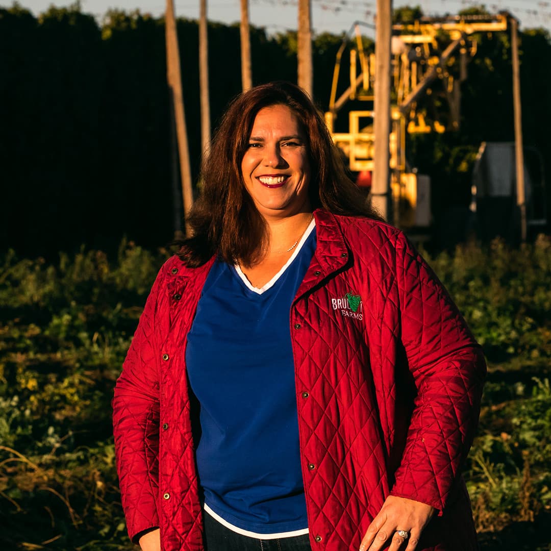 Grower stands in front of hop harvester