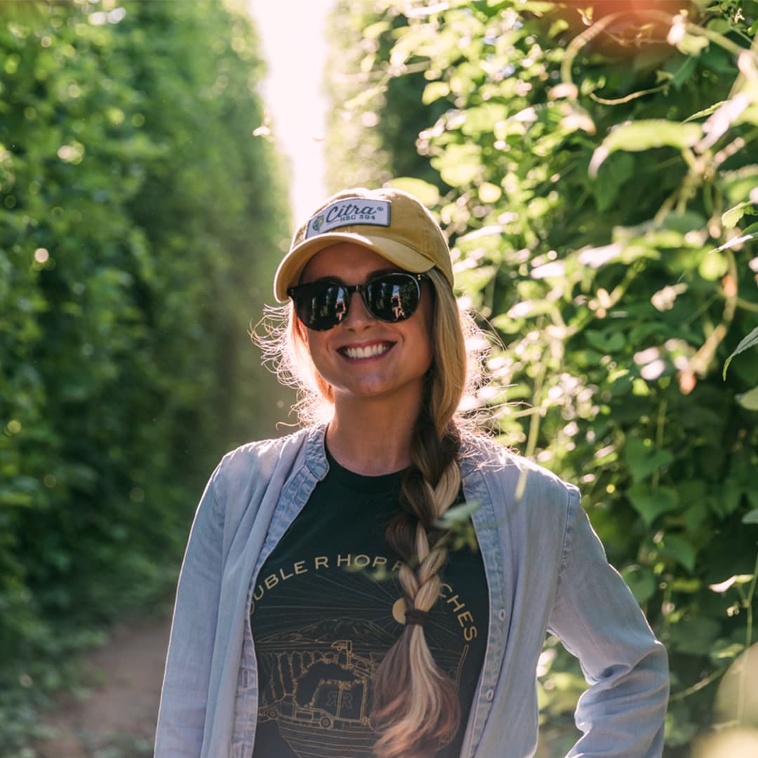 Grower stands in sunlit field of fresh hops
