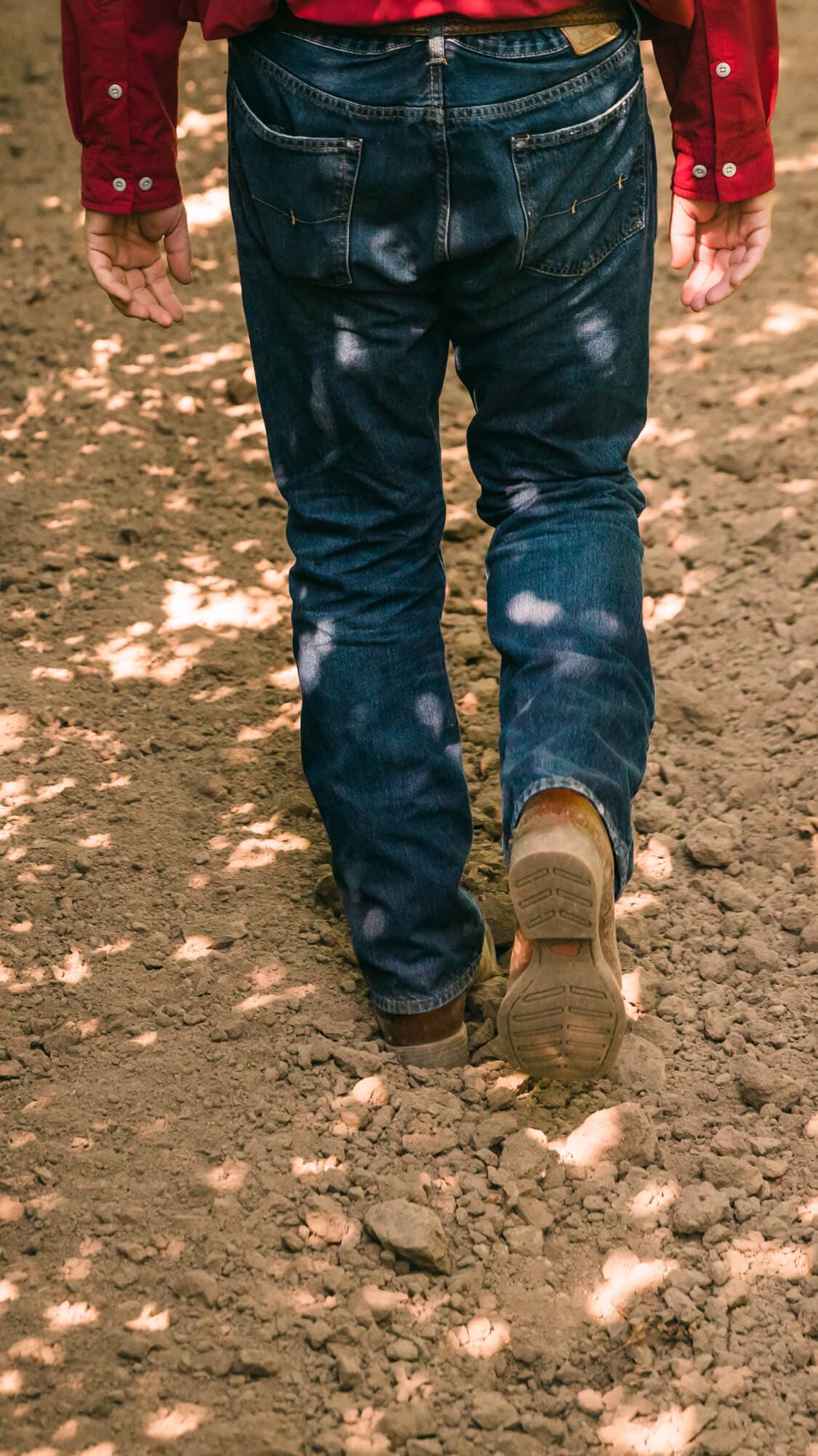 Boots walking in the dirt row of a hop yard