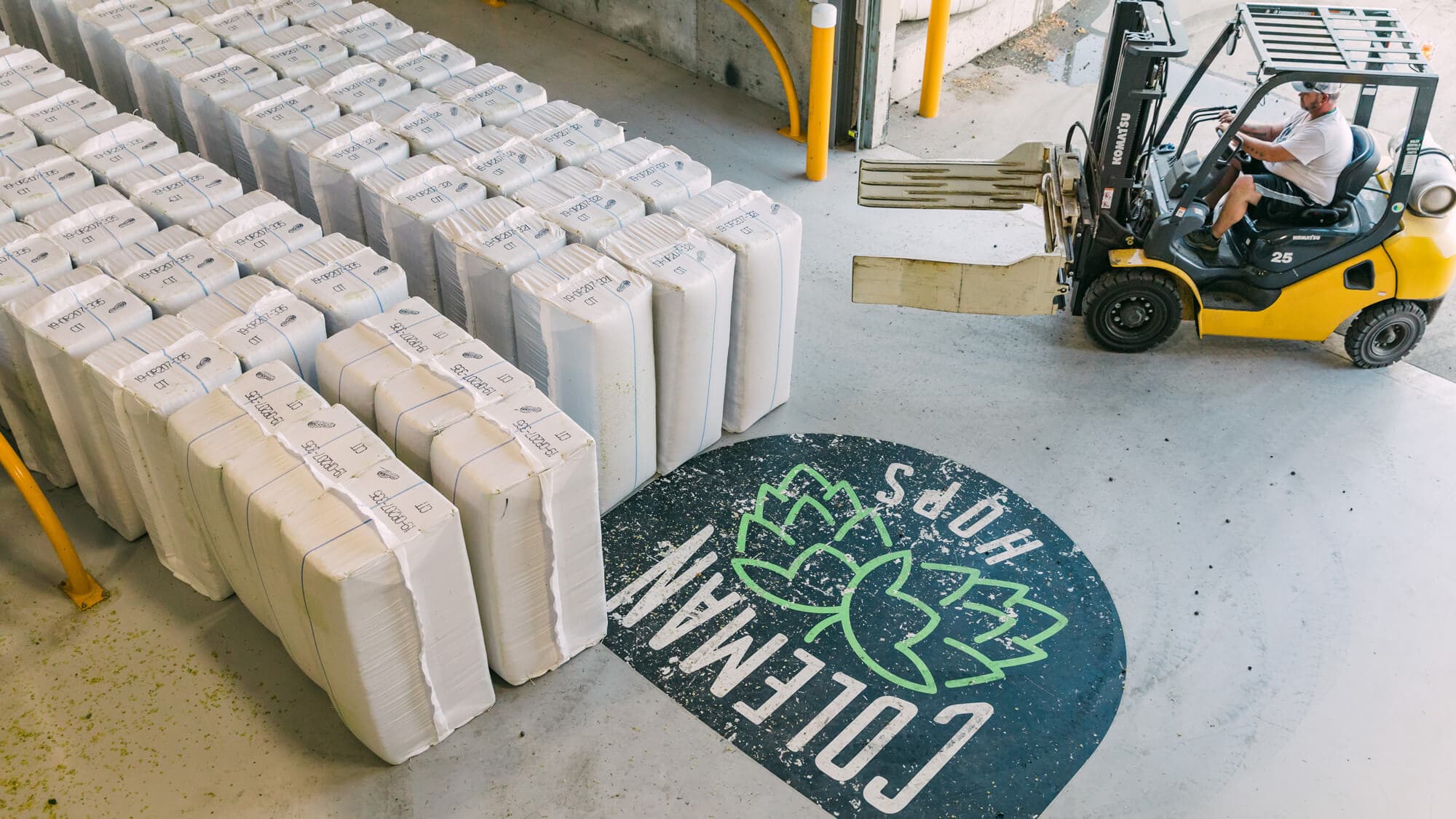 Image of forklift next to rows of hop bales